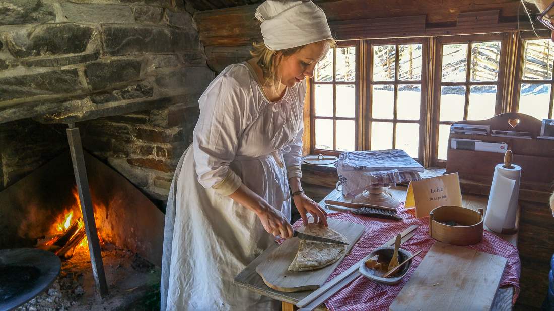24 Hours in Oslo: This picture shows a woman in a traditional Norwegian dress preparing flatbread.