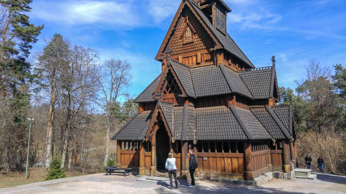 One Day in Oslo: This picture shows the Gol Stave Church, a wooden church located in the Norwegian Folk Museum. Two people stand in front of it.