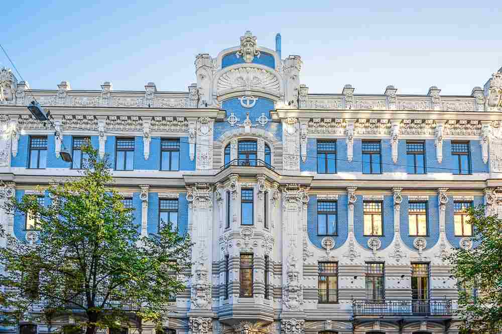Free Self-Guided Riga Walking Tour: The building at Elizabetes Street 10B is a great example of eclectic Art Nouveau and is characterized by plaster flourishes, gargoyles and is topped by two vast, deadpan faces.