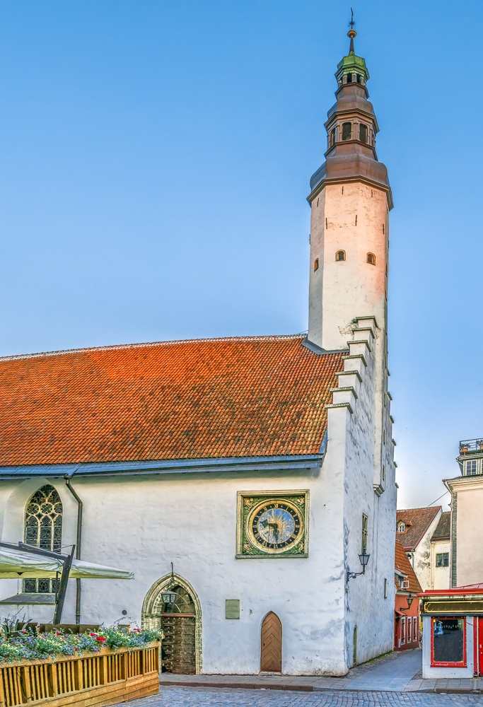 Churches in Tallinn: The Church of the Holy Spirit features a whitewashed exterior and stepped gable that are topped by a striking Baroque tower making it one of the most beautiful places to see on a Tallinn walking tour.