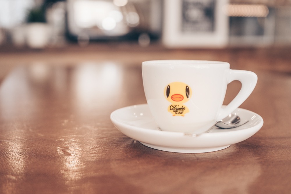 An espresso cup rests atop a wooden table at Ducks Coffee Shop in Graz.