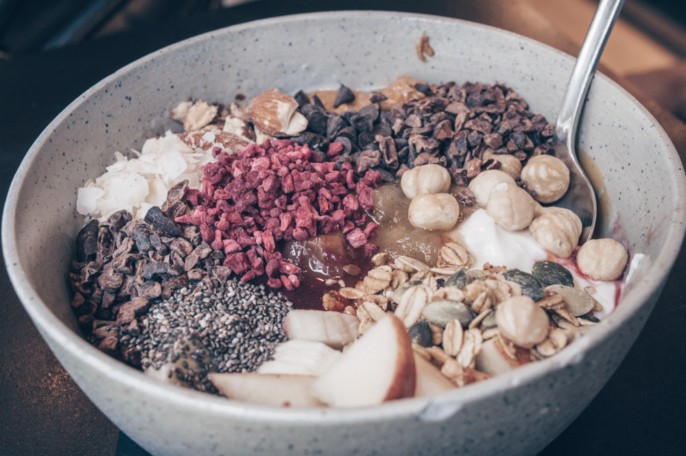 Where to eat in Copenhagen: A bowl of porridge consisting of chia seeds, cocoa nibs, apples, and bananas at GRØD