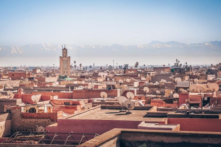 TMarrakech: Panoramic view of the red-roofed buildings with the Atlas Mountains in the background.