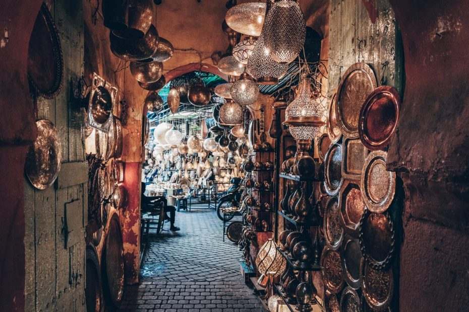 Marrakech Souks: Illuminated lanterns and copper plates on display in a narrow alley
