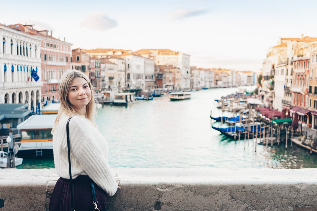 Beautiful woman on the Rialto Bridge in Venice with the Grand Canal in the background.
