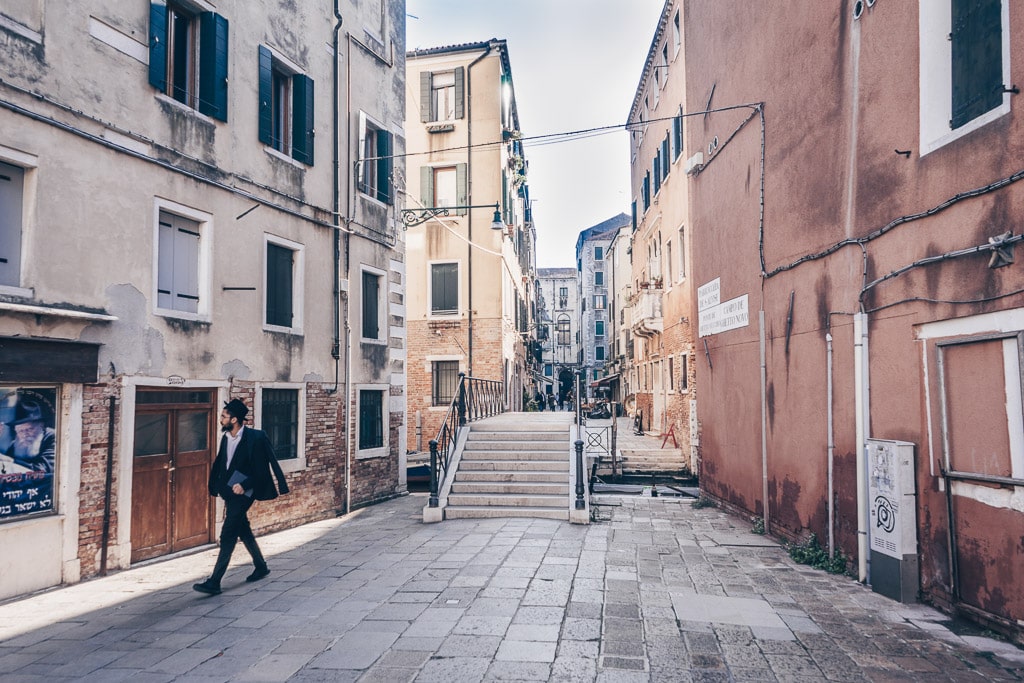 An Orthodox Jewish man walking on a quiet alley in the Jewish Ghetto of Venice.