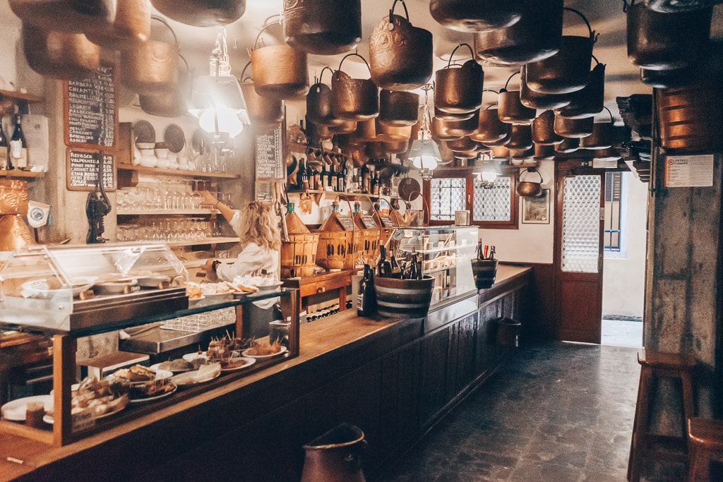 The dimly lit wood interior and dozens of copper pots hanging from the ceiling of Cantina Do Mori in Venice.
