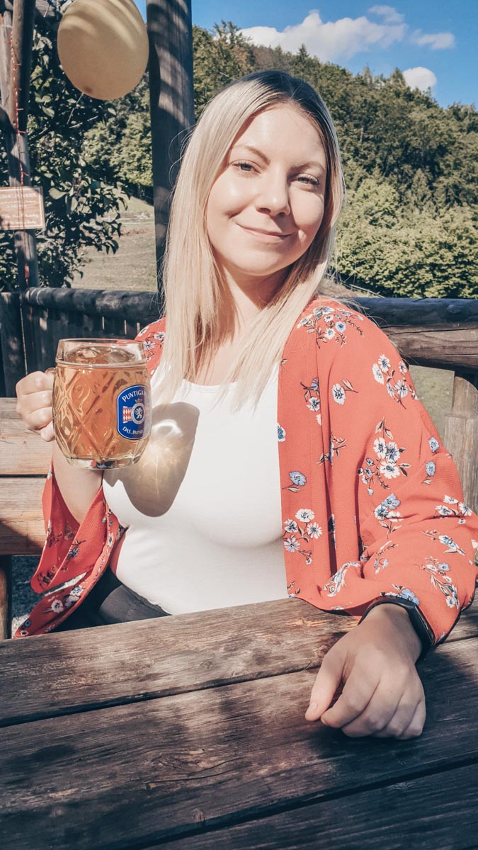 Beautiful blonde woman holding a glass of wine at a wine tavern in Graz, Austria