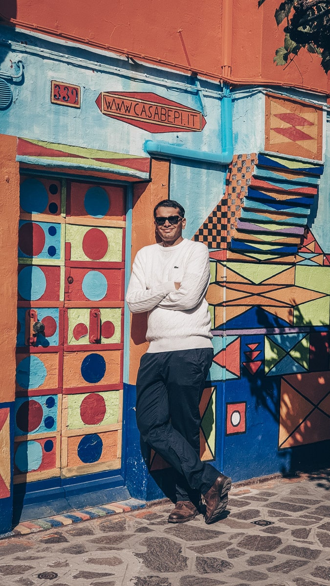 Burano photo spots: Man posing for a photo outside the multicolored Casa Bepi