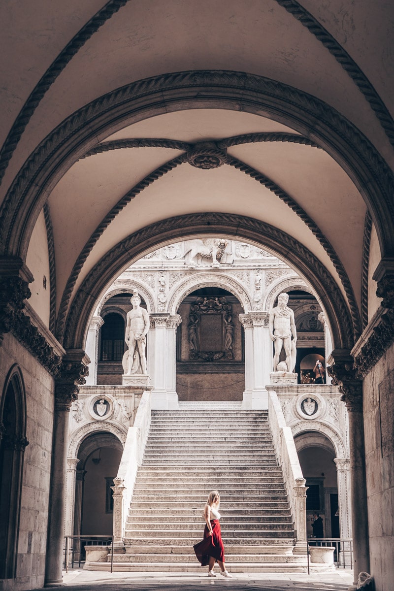 Venice Instagram Photo Spots: Woman posing for a photo at the bottom of the Giants' Staircase in the Doge's Palace