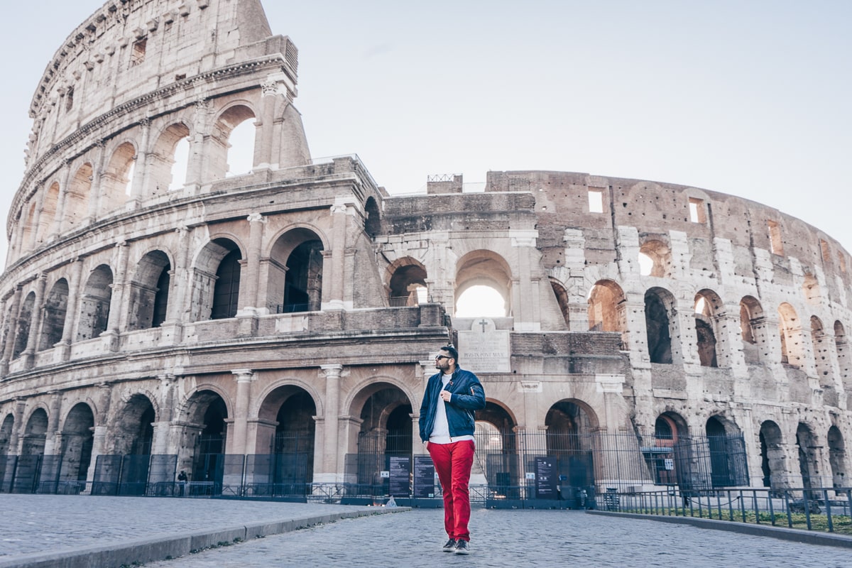 Rome photo spots: A man posing for a photo in front of the Colosseum in the early morning