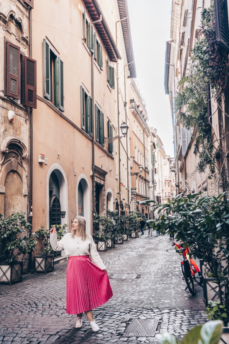 Best Rome Instagram locations: A woman posing for a photo on the charming Via dei Coronari 