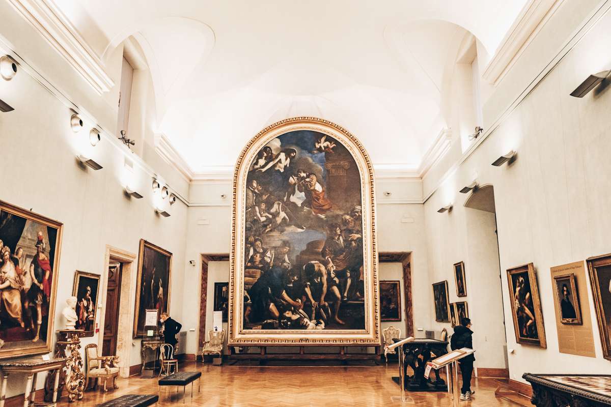 People admiring Guercino's colossal Burial of St. Petronilla painting in the Capitoline Museums