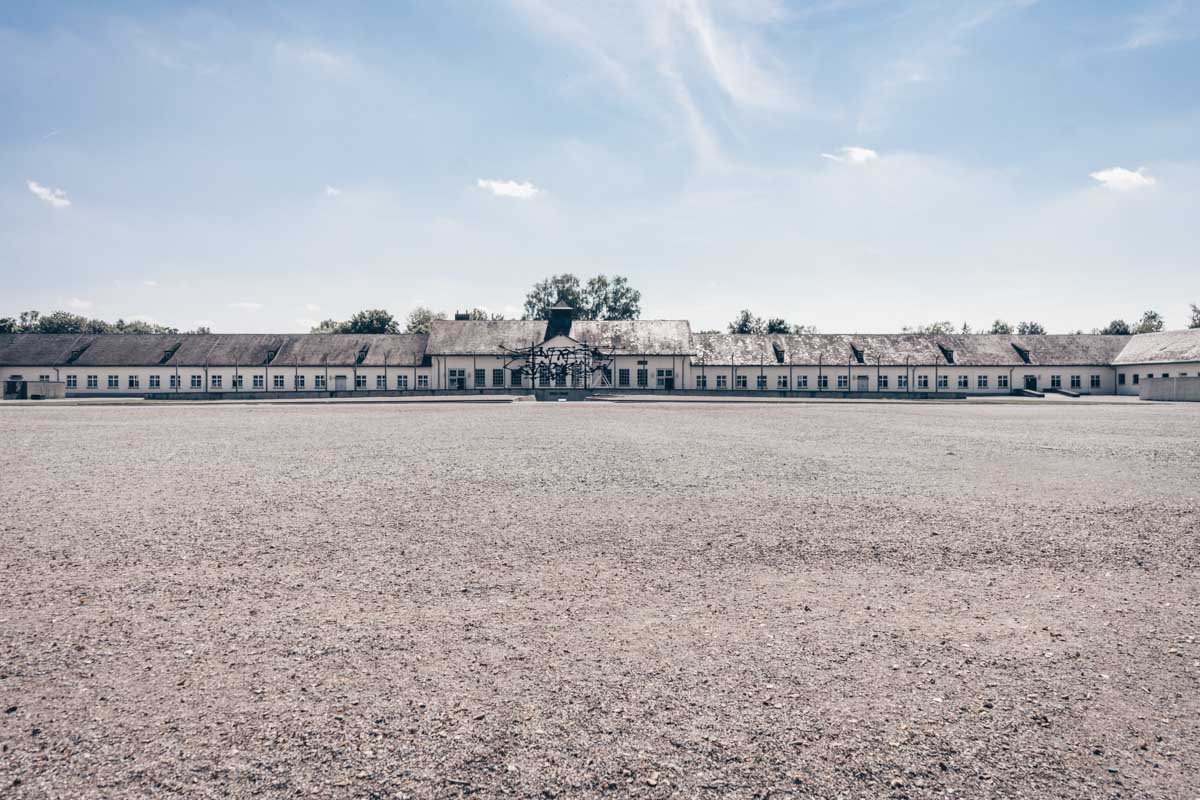 The sprawling roll-call yard of the Dachau Concentration Camp on a summer afternoon
