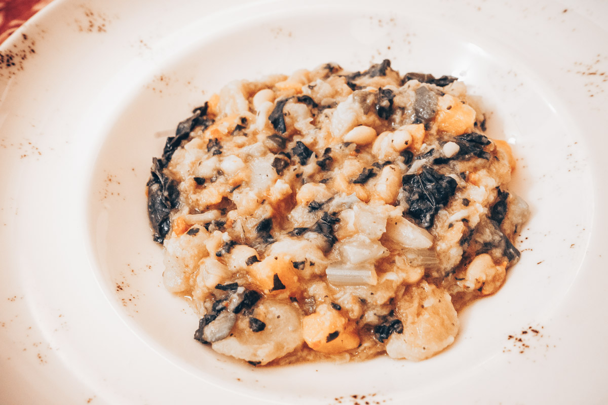 Tuscan Food: A bowl of Ribollita, a hearty Tuscan soup, brimming with cannellini beans, vegetables, and stale bread, 